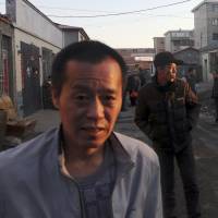 Miners Zhang Shucun (left) and Li Jianxiu (center) stand near other residents in the village of Jundeshan in northeastern China’s Heilongjiang province on Wednesday. Frustration among miners over unpaid wages has swelled to the brink of unrest in the Manchurian province. Anger in China's coal country as miners feel left behind