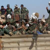 Shiite militiamen from Popular Mobilization forces head to the front line to fight Islamic State militants in the Samarra desert, on the border between Anbar and Salahuddin provinces, Iraq, Wednesday. Iraqi military and militia forces are again trying to clear Islamic State group fighters from the sprawling deserts that stand between recent territorial gains in Anbar province and Mosul. Iraqi forces evacuate 10,000 civilians in advance against Islamic State