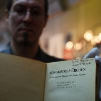Marcho Tomaschett of Swann Auction Galleries shows Anne and Margot Frank’s copy of Grimm’s Fairy Tales in New York on Wednesday. The book was published in 1925 in Vienna. Anne Frank's book of fairy tales up for auction