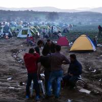 Refugees gather at their makeshift camp by the Greek-Macedonian border near the Greek village of Idomeni on Tuesday. Europe's daily refugee flood hides terrorists, and Russia, Assad fueling flow: top NATO brass