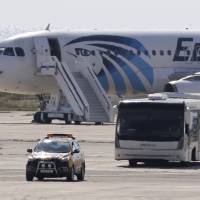 A bus carries away passengers from the hijacked EgyptAir aircraft after it landed at Larnaca airport Tuesday in Cyprus. Egypt plane hijacked to Cyprus, but officials rule out terrorism link