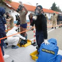 Volunteers train for a chemical attack at the Police National School of Nimes, southern France, Thursday. Law enforcement bracing for the European soccer championship are expected to train later with a fake explosion reminiscent of the suicide attacks on the French national stadium that night. The Nov.13 attacks began at the Stade de France stadium with three suicide bombers. France re-enacts Paris attacks, stages soccer stadium chemical drill