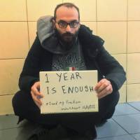 In this photo provided by Syrian refugee Fadi Mansour, Mansour is pictured holding a placard reading: “1 year is enough #I need my freedom” at Istanbul’s Ataturk airport, Tuesday. Amnesty International is calling for the immediate release of the Syrian national, who initially fled Syria in August 2012 to avoid military service and has been detained at Istanbul’s Ataturk Airport in “inhumane conditions” for one year. Istanbul airport like 'Terminal' for Syrian stuck over a year