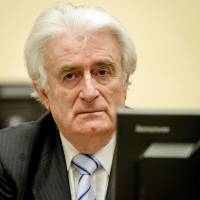 Former Bosnian Serb leader Radovan Karadzic sits in a courtroom in the Hague on Thursday. Srebrenica survivors say verdict on Karadzic too lenient, too late