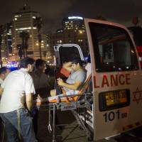A wounded man is evacuated from the scene of a stabbing attack in Jaffa, a mixed Jewish-Arab part of Tel Aviv, Tuesday. U.S. tourist slain as Palestinians wage knife attacks near Biden's Israel visit venue