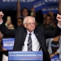 Democratic presidential candidate, Sen. Bernie Sanders, acknowledges supporters on arrival at a campaign rally Tuesday in Miami. Sanders is surprise victor in Michigan; Trump keeps winning