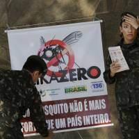 Army soldiers set up a sign Feb. 13 that reads in Portuguese “A mosquito is not stronger than an entire country” at the Central station in Rio de Janeiro as troops across Brazil try to tackle the Zika virus. Scientists may have the first evidence that Zika causes temporary paralysis, according to a new study of patients who developed the rare condition during an outbreak of the virus in Tahiti two years ago. The research was published online Monday in the journal Lancet. Tahiti Zika outbreak study indicates virus may cause temporary paralysis