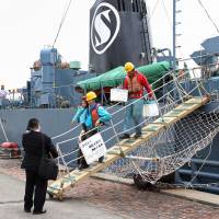 Workers disembark from a whaling ship at the port of Shimonoseki, Yamaguchi Prefecture, on Thursday. Japan's whaling fleet returns home from Antarctic hunt; catch remains unknown