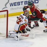Minnesota's Zach Parise (right) scores past Calgary goalie Niklas Backstrom in the first period on Thursday night. Parise powers Wild with first-period hat trick