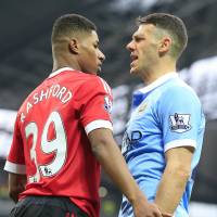 United's Marcus Rashford (left) and City's Martin Demichelis argue during their match on Sunday. United wins Manchester derby; Spurs prevail