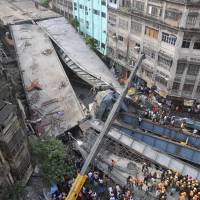 Residents and rescue workers clear rubble from a partially collapsed overpass in Kolkata on Thursday. Indian rescuers say no more survivors in collapsed overpass