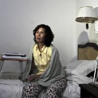In this June 30, 2010, file photo, Chinese lawyer Ni Yulan sits on a bed in a hotel in Beijing. Ni was awarded the State Department's International Women of Courage Award for her work defending people forcibly evicted from their homes. China stops Western diplomats from visiting dissident