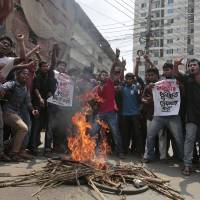 Bangladeshi students protest, seeking the arrest of three motorcycle-riding assailants who hacked student activist Nazimuddin Samad to death as he walked with a friend, in Dhaka Thursday. Police suspect 28-year-old Samad was targeted for his outspoken atheism in the Muslim majority country and for supporting a 2013 movement demanding capital punishment for war crimes involving the country's independence war against Pakistan in 1971. U.S. offers haven for Bangladesh bloggers after latest slaying of foe to radical Islam