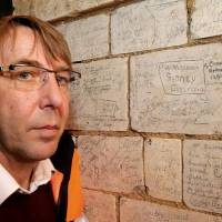 Archaeologist Gilles Prilaux, an INRAP (Institut National de Recherches Archéologiques Préventives) specialist on the First World War, poses near names etched in the stone walls on Thursday in the “underground city” of Naours, in the Somme, where some 3,000 graffiti inscriptions, mainly etched by Australian soldiers from the Australian and New Zealand Army Corps (ANZAC) the during WWI, are being registered. Somme battle soldiers' graffiti in cave network offer Great War insights