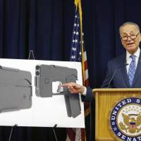 U.S. Sen Charles Schumer, (D-New York), points to a photograph of what appears to be a cell phone, but is actually a handgun, during a news conference in his office Monday in New York. According to the website of Ideal Conceal, the company that is developing the product, the handgun is a double-barreled .380 caliber gun that can serve as a concealed weapon. Senator seeks ATF probe into gun that folds down to look like iPhone