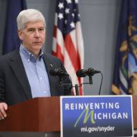 Gov. Rick Snyder speaks to the press on Wednesday, in Lansing, Michigan. Months after officials conceded that a series of bad decisions had caused a disaster, charges were filed against a pair of state Department of Environmental Quality employees and a local water treatment supervisor and stem from an investigation by the office of the attorney general. Lawyers say official misconduct may be hard to prove in Flint tainted water scandal