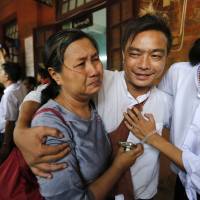 A student protester (center) and a family member cry after he was released by the new government's general amnesty at Tharrawaddy court on Friday. New Myanmar government begins releasing political prisoners