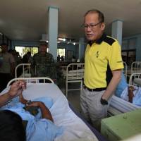 In this handout photo taken on April 13, 2016, Philippine President Benigno Aquino (R) speaks with one of the wounded soldiers who recently clashed with Abu Sayyaf militants, during a visit to a military hospital in the city of Zamboanga on Mindanao Island. Philippines' Aquino vows to 'neutralize' Abu Sayyaf kidnappers