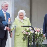 Pageantmaster Bruno Peek hands Britain's Queen Elizabeth II a torch for her to light the first beacon in honor of her 90th birthday in Windsor on Thursday with Britain's Prince Charles, Prince of Wales, following up. The queen lit the principal beacon that would set in train a series of beacons across the country and worldwide to mark her 90th birthday. 'Happy Birthday, dear Queenie' rings out as Elizabeth turns 90