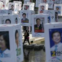 Candidates' posters for upcoming general elections are seen hanging over the Cheonggye stream in downtown Seoul on Monday. South Korea's pre-election speech freedoms falling victim to sudden online curbs