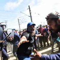 Migrants clash with police at a camp on Greece's northern border on Sunday. Dozens of people were hurt when migrants tried to break through a fence into Macedonia, and police fired tear gas in response. Rights groups urge next U.N. chief to tackle refugee problem