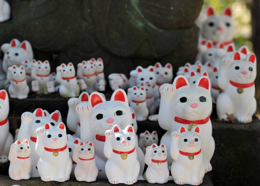 Maneki neko cat ornaments of different sizes are placed at Gotokuji Temple in Tokyo
