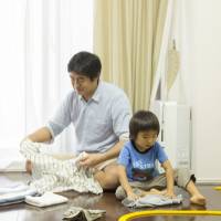 At-home-dad Taizo Horikomi folds laundry together with his sons in October. House husbands gaining acceptance in Japan as gender stereotypes ease
