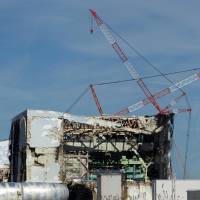 The No. 4 reactor at the Fukushima No. 1 nuclear power plant is seen through a bus window in this Nov. 12, 2011, file photo. IAEA review spurs Japan nuclear regulators to bolster safety regimen, look to U.S. for training