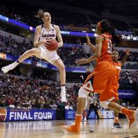 Connecticut’s Breanna Stewart grabs a rebound in front of Syracuse’s Briana Day on Tuesday in Indianapolis. UConn routs Syracuse for fourth straight title