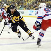 Penguins left wing Chris Kunitz (14) moves the puck as the Rangers' Keith Yandle defends on Saturday in Pittsburgh. Penguins beat Rangers, win series