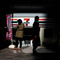 People stand outside a 7-Eleven convenience store near the headquarters of Seven & I Holdings in Tokyo in January 2015. Japan an alluring target for Standard Bank ATM thieves
