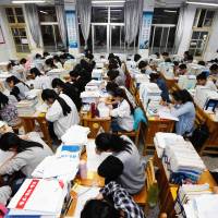 High school students study at night for college entrance exams in Lianyungang, China, on Tuesday. As more students seek to study abroad, a new report on cheating rings shows how a vibrant East Asian industry is corrupting the U.S. higher education system by gaming entrance exams, concocting college applications and completing college coursework on behalf of students — mostly Chinese nationals. Industry helps Chinese game their way into and through U.S. colleges