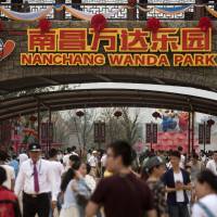 People walk through the entrance to the Nanchang Wanda Park theme park at the Wanda Cultural Tourism City in Nanchang in southeastern China’s Jiangxi province, Saturday. China's richest man declares war on Disney with giant theme park