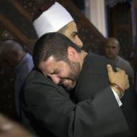 The imam of al-Thawrah mosque embraces Tarek Abu Laban, who lost four relatives in Thursday's EgyptAir plane crash, following prayers for the dead in Cairo on Friday. EgyptAir body parts and wreckage found