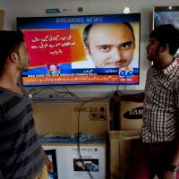 People watch news about the release of Ali Haider Gilani at a shop in Karachi, Pakistan, Tuesday. A joint raid by U.S. and Afghan forces on Tuesday rescued the former Pakistani prime minister’s son from a three-year-long Taliban captivity in Afghanistan, officials said. Headline reads “Ali Haider Gilani is released after three years from Afghanistan’s province Ghazni. U.S.-Afghan raid on al-Qaida turns up Taliban-abducted son of Pakistani's ex-leader