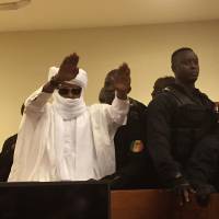Chad's former dictator, Hissene Habre, raises his hands after sentencing during court proceedings in Dakar Monday. Judge Gberdao Gustave Kam declared Habre guilty and sentenced him to life in prison for crimes against humanity, war crimes and torture, in a packed courtroom. Senegal court sentences Chad ex-dictator Habre to life for rape, torture, other crimes against humanity