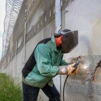 A Border Patrol agent patrol welds closed an illegal cut in the secondary fence at the U.S.-Mexico border Tuesday in San Diego. 'Illegal alien' stands as tea party effort gets to dictate Library of Congress labels