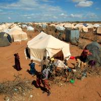 Refugees stand outside their tent at the Ifo Extension refugee camp in Dadaab, near the Kenya-Somalia border in Garissa County, Kenya, in 2011. Kenya looks to close mass refugee camps, send scared Somalis packing