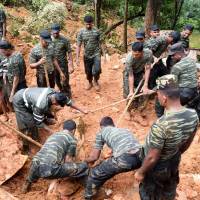 Sri Lankan military personnel take part in relief and rescue efforts following a landslide in the village of Bulathkohupitiya on Wednesday. Rescue workers on recovered the bodies of 17 villagers buried in landslides in Sri Lanka after three days of torrential rain. Sri Lanka rescuers use hands, sticks to search for over 200 families feared buried by landslides