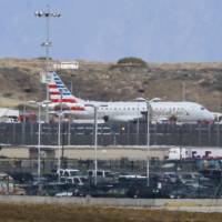 An American Airlines jet sits on a remote stretch of runway at Los Angeles International Airport Tuesday. American Airlines says officials screened the plane as a precaution after a noncredible threat was received about the flight from Houston. LAX SWAT team boards packed jet from Houston