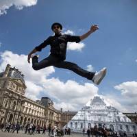 French artist and photographer JR jumps in front the Louvre Pyramid after recovering it 'with a surprising anamorphic image,' according to the museum in Paris on Wednesday. This recovering introduces the opening of JR exhibition 'Contemporary art JR at the Louvre' will run from May 25 to June 27. Louvre Pyramid vanishes in French street artist's optical illusion