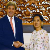 U.S. Secretary of State John Kerry shakes hands with Aung San Suu Kyi during a meeting in the Myanmar capital of Naypyidaw on Sunday. Kerry praises Myanmar's 'remarkable' evolution toward democracy following talks with Suu Kyi
