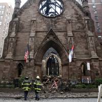 New York City firefighters (FDNY) walk through the debris following a fire at Manhattan's historic Serbian Orthodox Cathedral of Saint Sava in New York City Monday. Mystery blaze guts historic New York City church after Orthodox Easter service