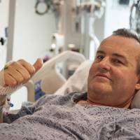 Thomas Manning gives a thumbs up Thursday after being asked how he was feeling following the first penis transplant in the United States, in Boston. The organ was transplanted from a deceased donor. Cancer patient, 64, at Massachusetts General gets first U.S. penis transplant