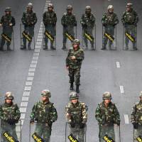 Thai soldiers form a line while guarding a bus stop area to prevent an anti-coup demonstration at Victory Monument in Bangkok on May 29, 2014. Thailand’s military seized power from an elected government just a week earlier. In Thailand, junta rule continues — with no end in sight