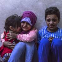 Children cry after leaving their home following a nearby rocket strike in the Turkish border town of Kilis on Saturday. Reports say Turkish Army strikes killed 55 Islamic State members across border in Syria
