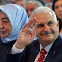 Binali Yildirim, Turkey’s current transportation minister and founding member of the Justice and Development Party, the nation’s governing party, and his wife, Semiha Yildirim, acknowledge supporters during a party congress in Ankara on Sunday. Yildirim, a longtime ally of President Recep Tayyip Erdogan, has been named new party chairman and Turkey’s next prime minister. After Davutoglu quits, Erdogan loyalist to be appointed Turkey's new prime minister