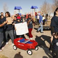 Olivia Samaripa (far right) with her daughter Aria, 2, pull a wagon carrying petitions in 2012 calling for their school to be converted to a charter school in the Mojave Desert town of Adelanto, California. More than 100,000 students in the nation's second-largest school district are now enrolled in charters, draining nearly $592 million from the budget in one school year alone. In Los Angeles, school board members are waging a battle to try and regain the public's trust in district schools. More students leaving U.S. public schools, entering charters: data