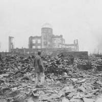 Atomic age dawns: An Allied correspondent stands amid rubble in Hiroshima on Sept. 8, 1945, a month after the first atomic bomb ever used in warfare was dropped by the U.S. on the city. By the end of the year, the bombs dropped on Hiroshima and Nagasaki and their fallout had killed over 210,000 people, mostly civilians. U.S. sees wars' end through the prism of Hiroshima
