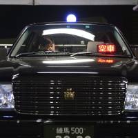 No free ride: A driver checks a Nihon Kotsu taxi at the firm's garage in Tokyo. Whither the taxi in a withering Japan?